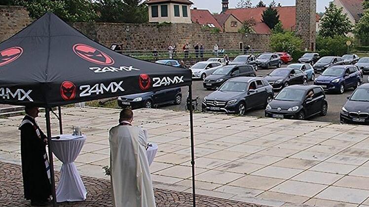 In etwa 70 Autos und rund um den Parkplatz lauschten Besucher des Open-Air-Autogottesdienstes den Worten der beiden Geistlichen, Pater Rudolf Theiler und Bernd Grosser. Foto: Helmut Will