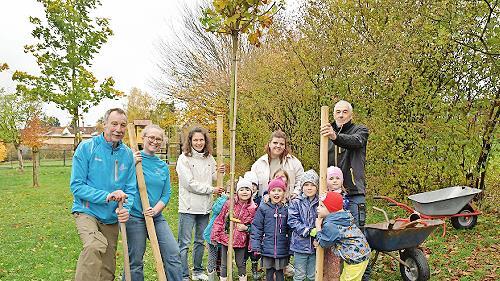 Die LG-Akteure zusammen mit einigen Kita- Kindern nach dem Einpflanzen des 2,20 Meter großen Kugelahornbaumes im Garten der Kita St. Elisabeth in Ludwigschorgast.