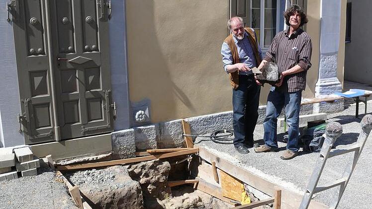 Reinhard Hüßner und Reiner Burkard präsentieren einen Teil der Türschwelle, die die genaue Datierung des Mauerrestes erlaubte.