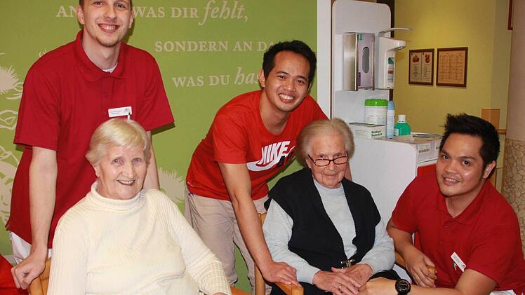 "Wir kommen gut zurecht - oder?", sagt Emma Kötzner (rechts). Uros Krivosejev aus Serbien und Alfredo Hidalgo sowie Lester Beltran von den Philippinen sorgen sich künftig um Bewohner des Dr. Maria Probst Seniorenheims wie sie und Monika Schäfer. Foto: Carmen Schmitt