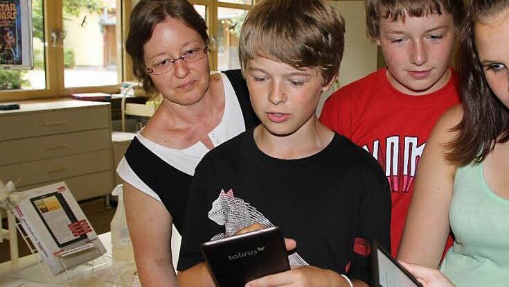 Da braucht Bibliotheksleiterin Heike Kettemer nicht viel erklären: Schnell klicken sich Kilian (v. l.), Paul, Alina und Raluca durch die Seiten.  Foto: uli
