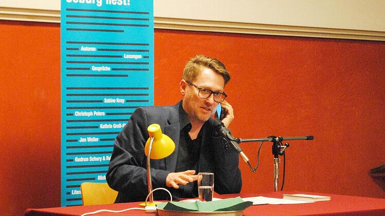 Jan Weiler muss auch während seiner Coburger Lesung mit seinem Pubertier telefonieren.  Foto: Carolin Herrmann