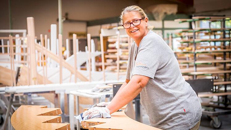Eine Frau bearbeitet eine Treppe bei Paltian Treppenbau GmbH.