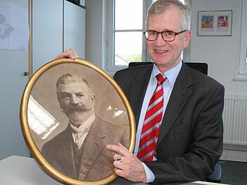 Er fühlt sich seinem Erbe verpflichtet und ist stolz auf 100 Jahre Rauschert Steinbach: Geschäftsführer Roland P. Rauschert mit dem Foto des Firmengründers Paul Rauschert. Foto: Veronika Schadeck