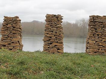 "Menosgada" heißt diese Installation Hubert Kollings aus Jurakalksteinen am Wiesener Wöhrdsee, die den Felsentürmen des Staffelbergs nachempfunden ist. Im Hintergrund lugt der echte Staffelberg empor. Foto: Hubert Kolling