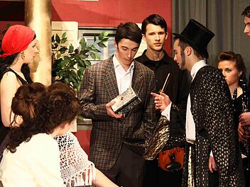 Der Zauberer Bastian Hunger überreicht dem Ehemann Simon Düsterdiek die Schatulle, Hotelmusiker, Gäste und Zauberergattin Lorena Helfrich schauen skeptisch zu. Foto: Thomas Dill