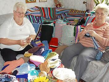 Rita Leitschuh und  Ella Schäfer (von links) aus Frankenbrunn beim Stricken. Der große Stapel mit Socken, Schals, Mützen und Decken, der unter den geschickten Händen der Frauen entstanden ist,   wird in Rumänien für Weihnachtsfreude bei den Bedürftigen sorgen.  Foto: Günther Straub