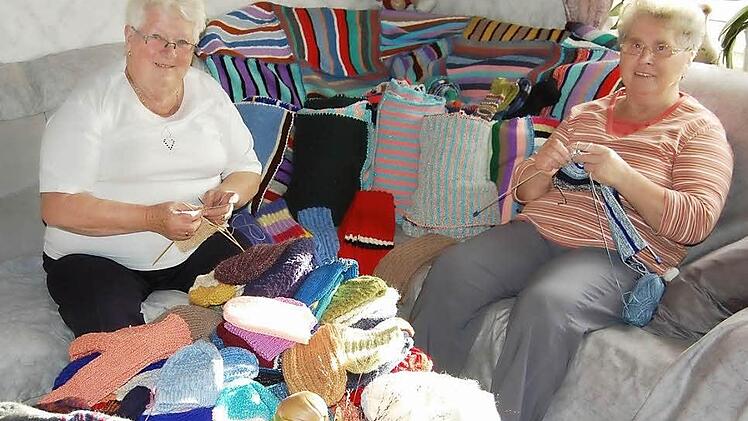 Rita Leitschuh und  Ella Schäfer (von links) aus Frankenbrunn beim Stricken. Der große Stapel mit Socken, Schals, Mützen und Decken, der unter den geschickten Händen der Frauen entstanden ist,   wird in Rumänien für Weihnachtsfreude bei den Bedürftigen sorgen.  Foto: Günther Straub