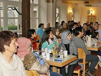 Fähnchen wehten an der Decke: Voll besetzt war der Pfarrsaal Oberschleichach, in den die Ministranten zum Willkommens-Café mit syrischen Asylbewerbern eingeladen hatten.  Foto: Sabine Weinbeer