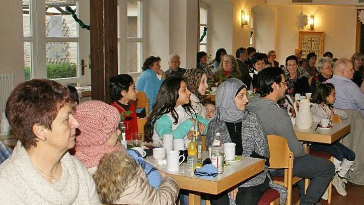 Fähnchen wehten an der Decke: Voll besetzt war der Pfarrsaal Oberschleichach, in den die Ministranten zum Willkommens-Café mit syrischen Asylbewerbern eingeladen hatten.  Foto: Sabine Weinbeer