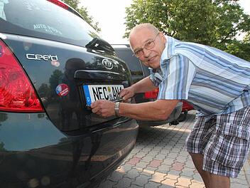 Bekam sein Lachen gar nicht mehr aus dem Gesicht: Anton Nossel war der erste Neustadter Bürger, der sich das NEC-Kennzeichen an sein Auto machte. Kurz nach 7.30 Uhr verließ er den Parkplatz vor dem Landratsamt. Fotos: Thomas Heuchling