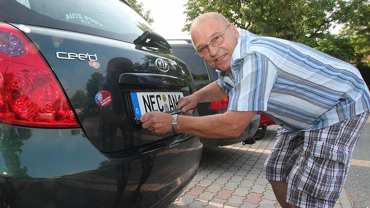 Bekam sein Lachen gar nicht mehr aus dem Gesicht: Anton Nossel war der erste Neustadter Bürger, der sich das NEC-Kennzeichen an sein Auto machte. Kurz nach 7.30 Uhr verließ er den Parkplatz vor dem Landratsamt. Fotos: Thomas Heuchling
