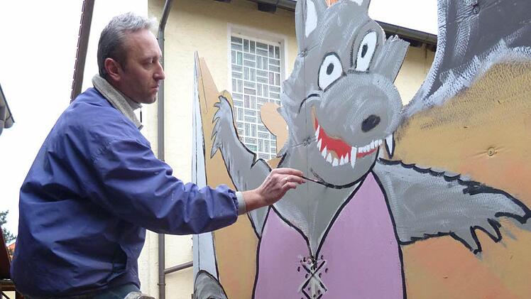 Jürgen Ziegelhöfer malt den tanzenden Wolf auf den Faschingswagen. Foto: Michael Schnapp