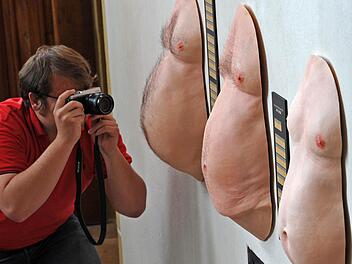 Ein Fotograf lichtet in einer Ausstellung in Meissen (Sachsen) die durchschnittlichen Bierbäuche des Sachsen (links), des Deutschen (Mitte) und des Hessen (rechts) ab.  Foto: Matthias Hiekel/dpa