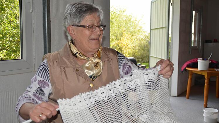 Inge Rottenberger hat ausrangierte Scheibengardinen von zu Hause mitgebracht. Diese sollen die Fenster der neuen Gerätehalle verschönern. Foto: Kathrin Kupka-Hahn