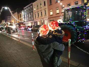 Buntgeschmückte Traktoren fahren durch Hof