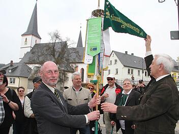 Robert Strobel vom Hauptverein hebt den Wimpel hoch - es ist Brauch, dass der Wimpel nicht gefahren werden darf, sondern von Frankenwaldtag zu Frankenwaldtag zu Fuß befördert wird. Die Zeyerner Wanderer waren sechs Stunden unterwegs. Fotos: Sonja Adam