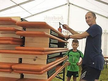 Benjamin schaut seinem Papa Alexander Kittel zu, der mittels eines Gasbrenners die neuen Biergarnituren der Dorfgemeinschaft Hesselbach brandmarkt. Foto: Heike Sch&uuml;lein