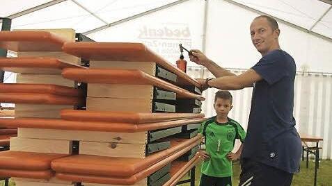 Benjamin schaut seinem Papa Alexander Kittel zu, der mittels eines Gasbrenners die neuen Biergarnituren der Dorfgemeinschaft Hesselbach brandmarkt. Foto: Heike Sch&uuml;lein