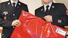 Kreisbrandinspektor Johannes Schmitt (rechts) übergab Kommandanten Alexander Jantscher einen Rauchvorhang. Foto: erl