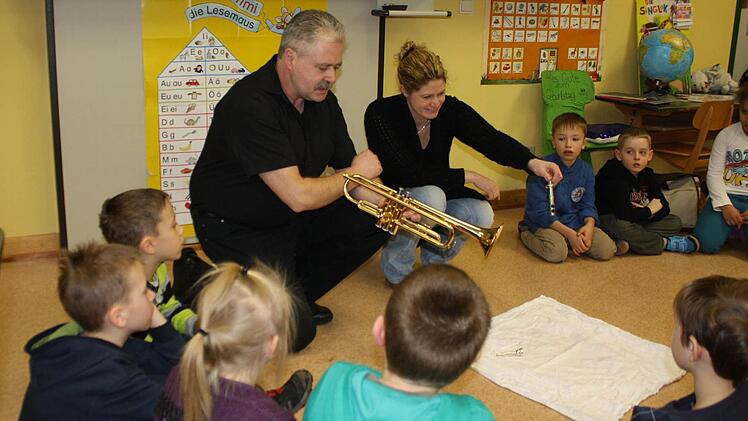 Der Vorsitzende des Musikzugs Wildflecken, Jürgen Köstler, erklärt vor der Musiklehrerin Yvonne Roth-Wächter allen Kindern die Trompete. Foto: Anke Schmitt-Gundelach