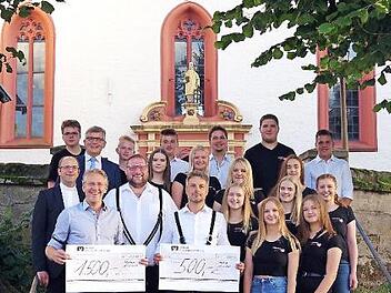 Die Jugendlichen mit den Spendenempfängern sowie Pfarrer Michael Gräf (mittlere Reihe, links) bei der Spendenübergabe  Foto: Heike Schülein