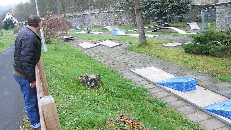Ein Passant sieht sich die Minigolfanlage über den Zaun hinweg an. Foto: Walter Hanslok