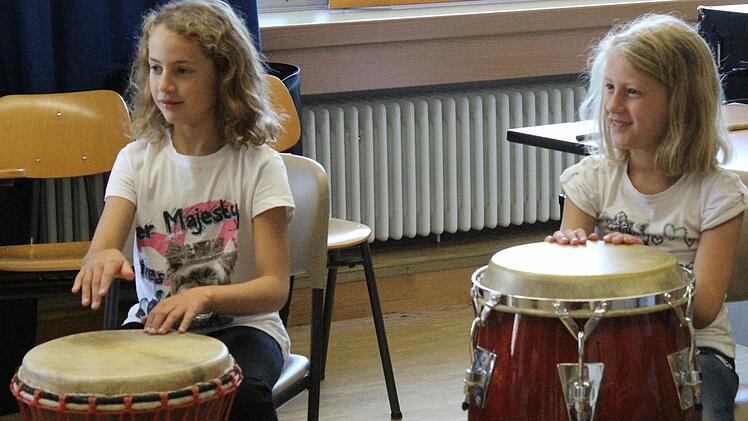 Die Schwestern Sophia und Susanna lauschen ganz gespannt, was Paulo ihnen übers Trommeln erzählt.