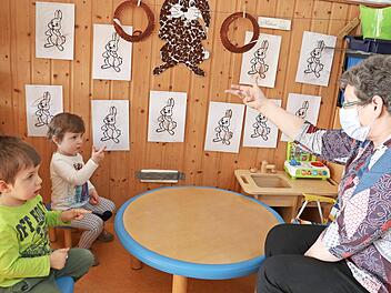 Mit Fingerspielen können die sprachlichen Fähigkeiten der Kinder gefördert werden, auch wenn Gruppenleiterin Sigrid Flurschütz eine Maske trägt. Deshalb schauen ihr Nico Geiger und Louise Albert ganz genau zu.