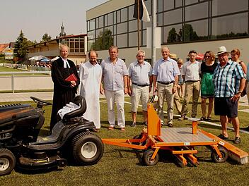 Das richtige "Werkzeug" hat man in Sand auch, um den Kunsrasenplatz angemessen pflegen zu können; unser Bild zeigt (von links): Pfarrer Hans-Christian Neiber, Pastoralreferent Rudi Reinhart, Bürgermeister Bernhard Ruß, Zweiten Bürgermeister Gerhard Zösch und Landrat Wilhelm Schneider bei der offiziellen Übergabe des neuen Platzes mit Platzwart Günther Flachsenberger ( Dritter von rechts) und dem neuen Pflegegerät. Foto: Günther Geiling