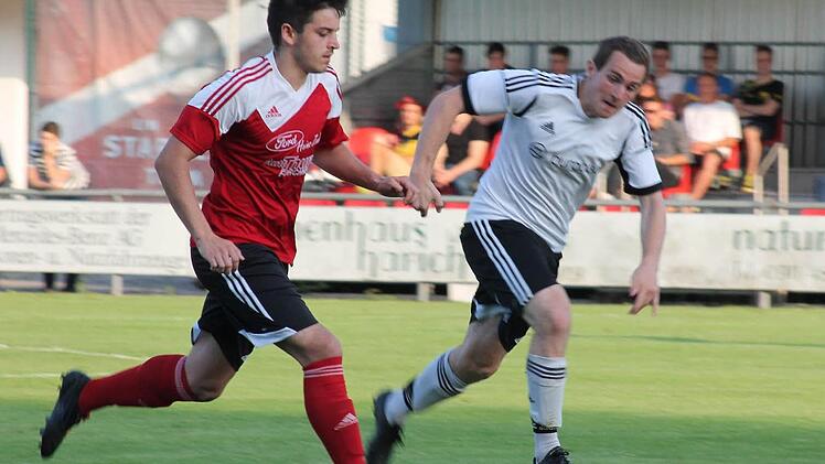 Der Adelsdorfer Dominik Leuner (rotes Trikot) behauptet den Ball im Mittelfeld gegen einen Kontrahenten des TSV Greding.  Fotos: Johannes Höllein