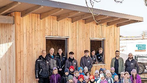 Das Bau-Team von Hanse Haus, Yanik Berberich (Leiter der KiTa St. Anna in Schondra) und die Kinderschar freuen sich &uuml;ber das neue Ger&auml;tehaus.