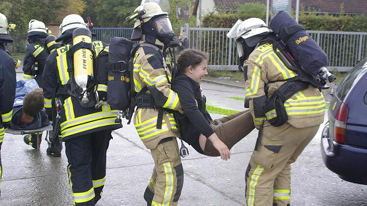 Atemschutzträger der Feuerwehr bringen die Unfallopfer aus dem Gefahrenbereich. Foto: Winfried Ehling