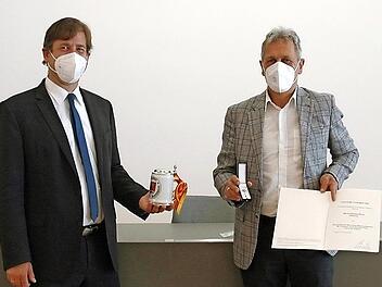 Landrat Hermann Ulm (l.) zeichnet Johannes Pinzel mit dem Ehrenzeichen des Ministerpräsidenten aus.