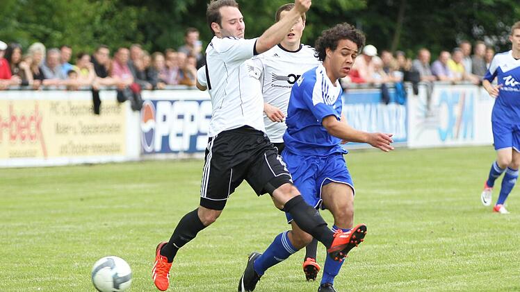 atrick Gierlich versucht den Frohnlacher Doppeltorschützen Tevin McCullough (blau) bei seinem Torschuss zu stören. Foto: Heinrich Weiß