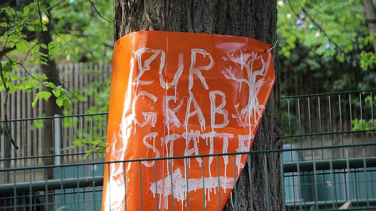 Mit Plakaten weisen Naturschützer auf die aus ihrer Sicht unnötigen Baumfällmaßnahmen auf dem Gelände der Bergkirchweih in Erlangen hin. Foto: Christian Bauriedel