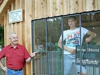 Wilfried Sünkel ist Vorsitzender eines engagierten Vereins. Frank Freitag ist Vereinsmitglied und hat Humor genug, sich für das Foto ins Innere des Wiegehäuschens zu begeben und eine alte Bekanntmachung in die Kamera zu halten.  Foto: Markus Häggberg