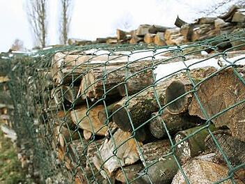 Willi Gebert hat seinen Holzstoß mit einem Maschendrahtzaun umwickelt, um die Scheite vor Langfingern zu schützen. Fotos: Sabine Paulus