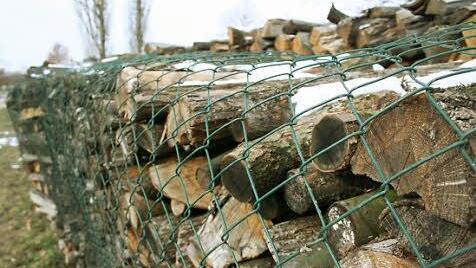 Willi Gebert hat seinen Holzstoß mit einem Maschendrahtzaun umwickelt, um die Scheite vor Langfingern zu schützen. Fotos: Sabine Paulus