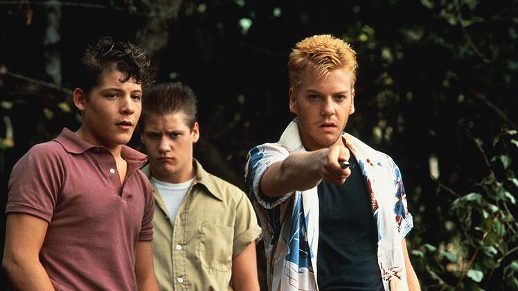 Auch die Rowdies Eyeball Chambers (Bradley Gregg, links), Vince Desjardins (Jason Oliver, Mitte) und deren Anf&uuml;hrer "Ace" Merrill (Kiefer Sutherland) haben es sich zum Ziel gemacht, die Leiche zu finden.