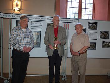 Horst Gundel, Pfarrer Andreas Sauer und Klaus Engelhardt zeigen die Ausstellung zur Geschichte des "Pulverkelchs" von St. Georg. Foto: Rainer Lutz
