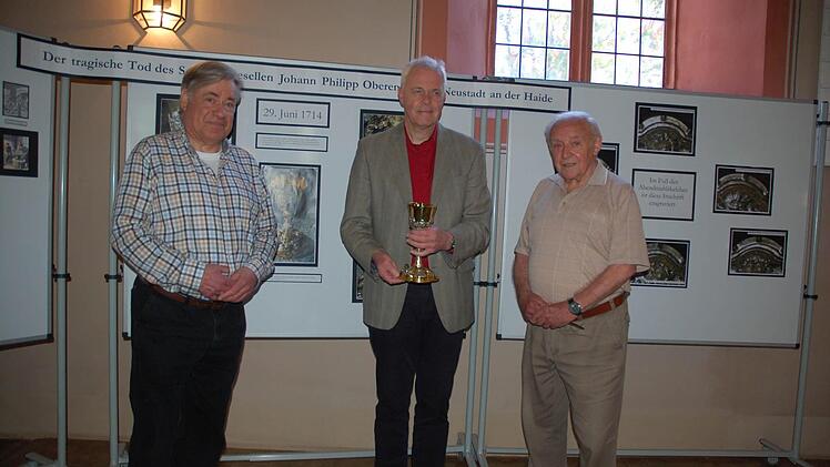 Horst Gundel, Pfarrer Andreas Sauer und Klaus Engelhardt zeigen die Ausstellung zur Geschichte des "Pulverkelchs" von St. Georg. Foto: Rainer Lutz