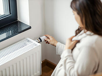 Heizsaison Heizkosten Heizrechnung Frau Rechnungen Heizung Heizk&ouml;rper F&uuml;&szlig;e w&auml;rmen Energiesparen Energieeffizienz Thermostat Entl&uuml;ften Fensterdichtungen D&auml;mmung Haushalt Budget Spartipps Herbst Winter Wohnung Haus Verbrauch Z&auml;hlerstand Nachtabsenkung Umw&auml;lzpumpe Gasprices Strompreise CO2 W&auml;rmeverlust