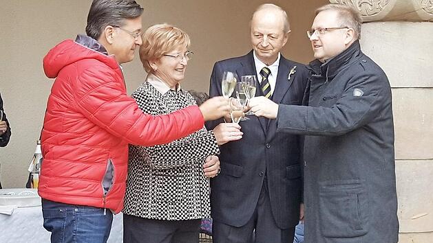B&uuml;rgermeister Karsten Fischkal (links) und Pfarrer Thomas Ringer (rechts) sto&szlig;en mit Ehepaar Go&szlig; auf die Goldene Hochzeit an.  Foto: Blum