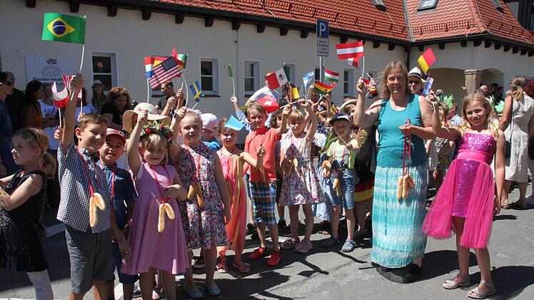 "Fremde Länder" lautet das Motto des Wiesenfestes. Freudig schwenken die Kinder aus der ersten Klasse ihre Flaggen. Foto: Stephan Stöckel