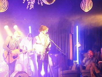 Samuel Harfst mit Band spielt auf der Bühne "Ein Privileg zu sein", während Samuel Koch (rechts) im Ohrensessel mitsingt.  Foto: Sarah Dann