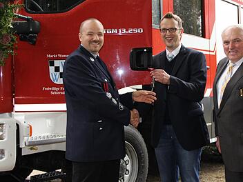 Bürgermeister Andreas Pöhner (Mitte) übergibt den Schlüssel für das neue Löschgruppenfahrzeug an den Schirradorfer Kommandanten Thorsten Krause. Altbürgermeister Günter Pfändner (rechts) hatte den Kauf des Fahrzeugs auf den Weg gebracht. Foto: Katharina Müller-Sanke