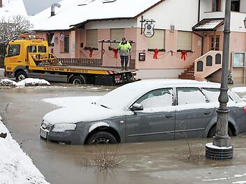 Georg Langosch (im Hintergrund) kam mit seinem Abschleppwagen nicht an den in den Fluten stehenden Audi heran. Die über die Ufer getretene Aisch hatte im Dezember 2010 das Sportgelände des ASV Höchstadt unter Wasser gesetzt.  Foto: Andreas Dorsch