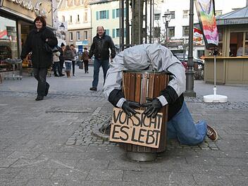 Den Kopf in der Mülltonne und ein Warnschild ,,Vorsicht: Es lebt!'' - das ist eines der neuen Kunstwerke, die die Schüler des Caspar-Vischer-Gymnasiums in der Innenstadt aufgestellt haben. Fotos: Sonja Adam
