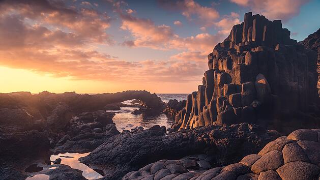 Langzeitbelichtung. Felsenstrand mit einem natürlichen Bogen bei Sonnenuntergang. Charco Azul. Insel El Hierro. Kanarische Inseln   Long exposure. rocky beach with a natural arch at sunset. Charco Azul. El Hierro island. Canary Islands